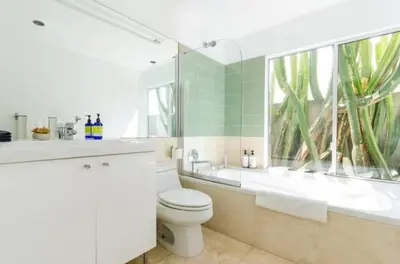 a bathroom with a toilet and a tub and a sink at Venice Place in Los Angeles