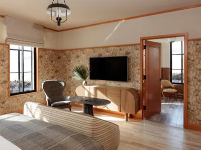 a living room with a couch and a tv on a wall at Santa Monica Proper Hotel, a Member of Design Hotels in Los Angeles
