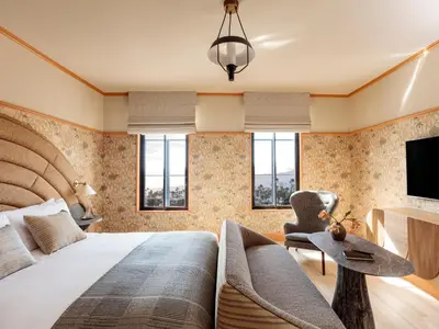 a bedroom with a bed and a chair and a television at Santa Monica Proper Hotel, a Member of Design Hotels in Los Angeles