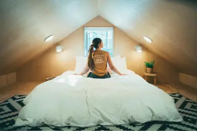 a woman sitting on a bed in a attic at Colorado Lodge in Big Bear Lake