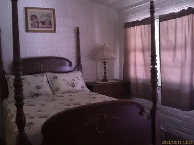 a bedroom with a bed and a lamp and a window at Ranch Motel in Tehachapi
