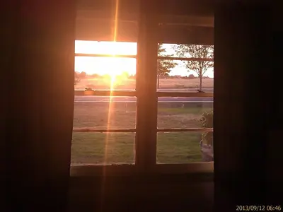 a window with a view of the sunset seen through it at Ranch Motel in Tehachapi