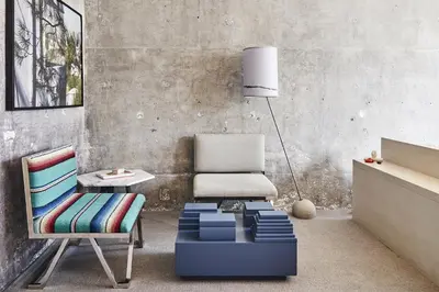 a living room with a chair and a blue ottoman at The LINE Hotel LA in Los Angeles