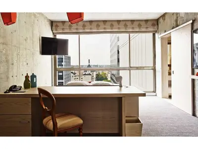 a desk with a chair in a room with a large window at The LINE Hotel LA in Los Angeles