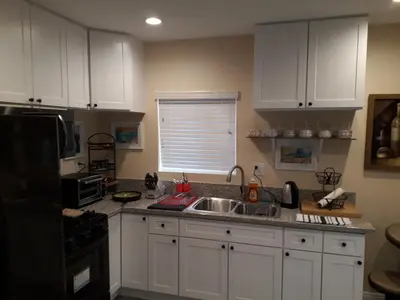 a kitchen with white cabinets and a sink at Comfortable Luxury Studio in Los Angeles