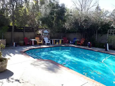 a swimming pool with a table and chairs in a backyard at Comfortable Luxury Studio in Los Angeles