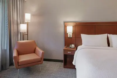 a hotel room with a bed and a chair at Courtyard Long Beach Airport in Long Beach