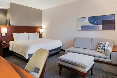 a hotel room with a bed and a couch at Courtyard Long Beach Airport in Long Beach