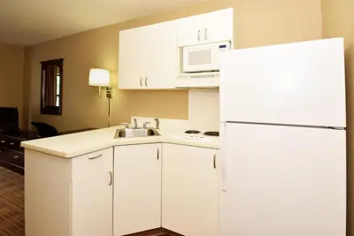 a kitchen with white cabinets and a white refrigerator at Extended Stay America Suites - Orange County - Huntington Beach in Huntington Beach