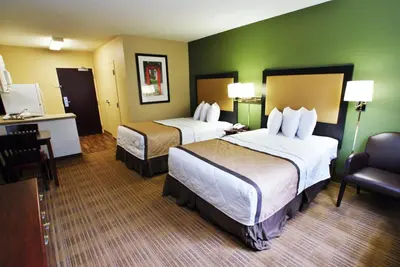 a hotel room with two beds and a chair at Extended Stay America Suites - Orange County - Anaheim Convention Center in Anaheim