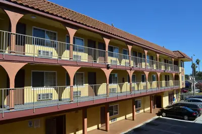 a building with balconies and cars parked in a parking lot at Cloud 9 Inn LAX in Inglewood
