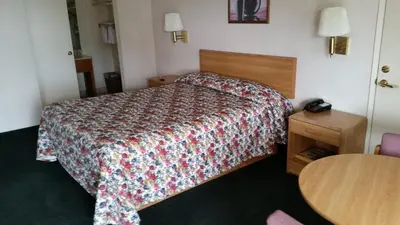 a hotel room with a bed and a table at Economy Inn Motel in Sylmar