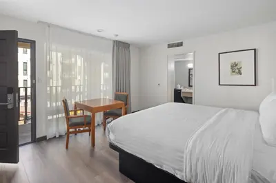 a bedroom with a bed and a table and a desk at Vagabond Inn Glendale in Glendale