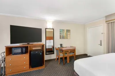 a hotel room with a television and a bed and a desk at Best Western Oxnard Inn in Oxnard
