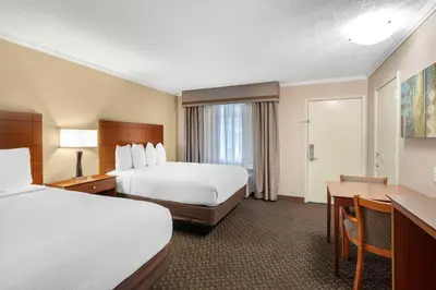 a hotel room with two beds and a desk at Best Western Oxnard Inn in Oxnard