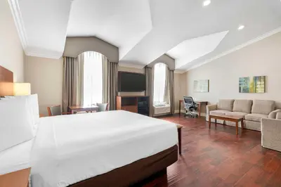 a bedroom with a bed and a living room at Best Western Oxnard Inn in Oxnard