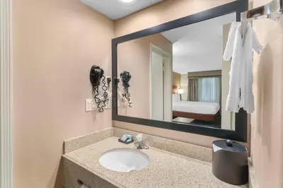 a bathroom with a sink and a large mirror at Best Western Oxnard Inn in Oxnard