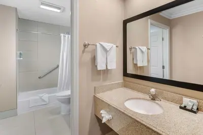 a bathroom with a sink and a toilet and a mirror at Best Western Oxnard Inn in Oxnard