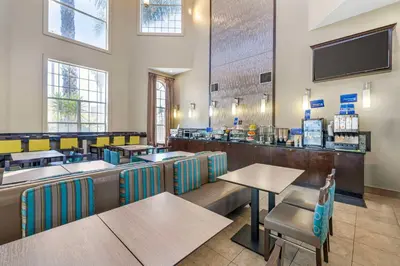 a restaurant with tables and chairs and a bar at Best Western Oxnard Inn in Oxnard