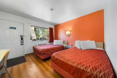 a hotel room with two beds and an orange wall at Motel 6-Big Bear Lake, CA in Big Bear Lake