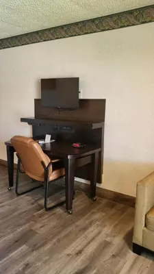 a desk with a television and a chair in a room at Valley Inn in Mission Hills