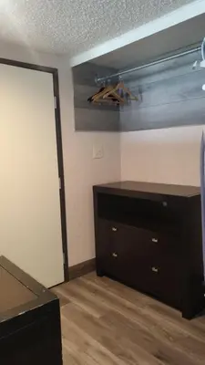 a room with a dresser and a closet with a door at Valley Inn in Mission Hills