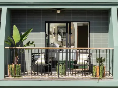 a balcony with chairs and plants in front of a blue wall at Palihotel Hollywood near Universal Studios in Los Angeles