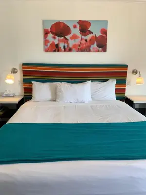 a bedroom with a bed with a blue and white blanket at Sandyland Reef Inn in Carpinteria