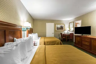 a hotel room with two beds and a flat screen tv at Quality Inn Near China Lake Naval Station in Ridgecrest