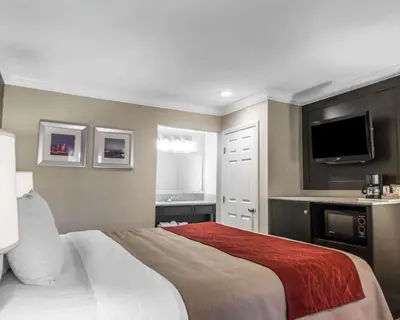 a bedroom with a large bed and a flat screen tv at Quality Inn Downey in Downey