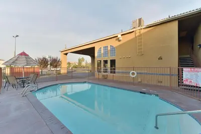 a large swimming pool in front of a building at Rodeway Inn Delano in Delano