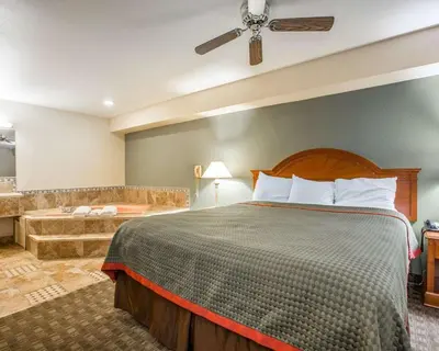 a hotel room with a bed and a bathroom at Rodeway Inn Delano in Delano