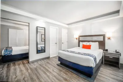 a hotel room with two beds and a mirror at Inn at 50 Long Beach Convention Center in Long Beach