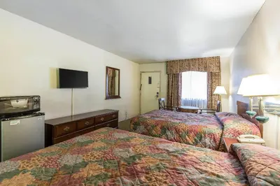 a hotel room with two beds and a television at Rodeway Inn Magic Mountain Area in Castaic