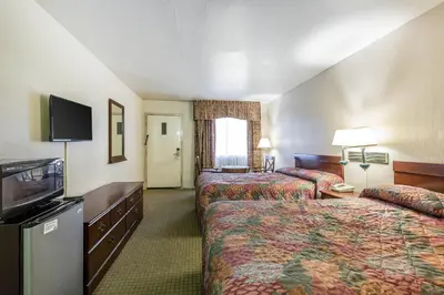 a hotel room with two beds and a flat screen tv at Rodeway Inn Magic Mountain Area in Castaic