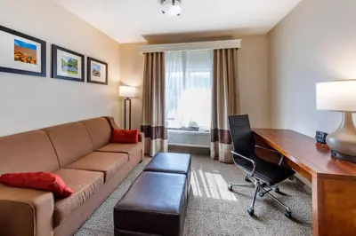 a living room with a couch and a desk at Comfort Suites Near Six Flags Magic Mountain in Stevenson Ranch