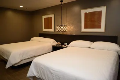 two beds in a hotel room with white sheets at Hotel Le Reve Pasadena in Pasadena