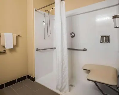 a bathroom with a shower with a white shower curtain at Comfort Suites Victorville-Hesperia in Victorville