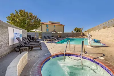 a swimming pool with a hot tub in a yard at Comfort Inn & Suites Lancaster Antelope Valley in Lancaster