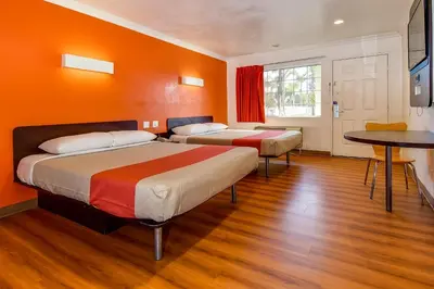 two beds in a room with orange walls at Motel 6 Garden Grove in Anaheim