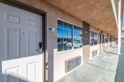 a building with a white door and a parking lot at Rodeway Inn Barstow Route 66 in Barstow