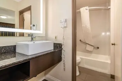 a bathroom with a white sink and a toilet at Rodeway Inn Barstow Route 66 in Barstow