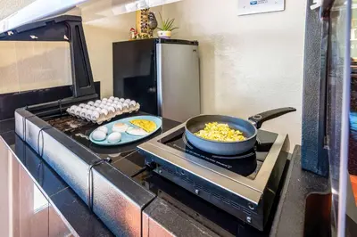 a kitchen with a stove with a pan of food on it at Rodeway Inn Barstow Route 66 in Barstow