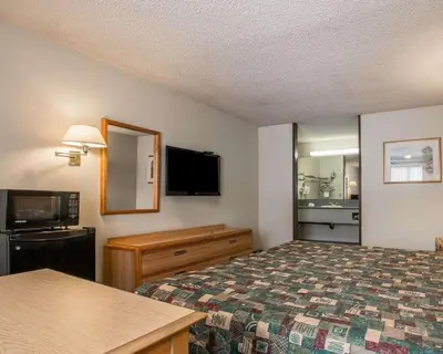 a hotel room with a bed and a flat screen tv at Palm Inn Hotel near Tyler Mall Riverside in Riverside