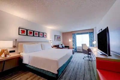 a hotel room with a bed and a desk with a television at Hilton Garden Inn Anaheim/Garden Grove in Anaheim