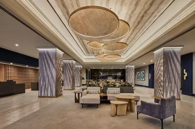 a lobby of a hotel with chairs and tables at Hotel Fera Anaheim, a DoubleTree by Hilton Hotel in Anaheim