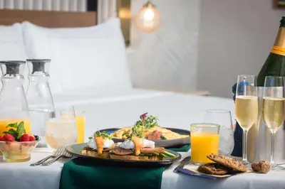a table with a plate of food and glasses of champagne at Hotel Fera Anaheim, a DoubleTree by Hilton Hotel in Anaheim