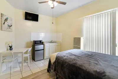 a bedroom with a bed and a table and a kitchen at Pads on Pasadena Ave in Los Angeles