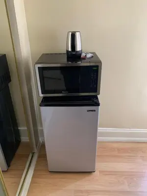 a microwave sitting on top of a refrigerator at Pads on Pasadena Ave in Los Angeles