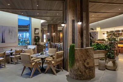 a restaurant with a table and chairs and a bar at 1 Hotel West Hollywood in Los Angeles